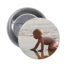 Baby, das im Sand auf dem Strand spielt Anstecknadelbutton