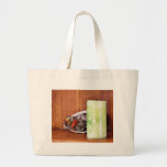 Kerze auf einem Regal mit etwas Pinecones und Mate Tasche