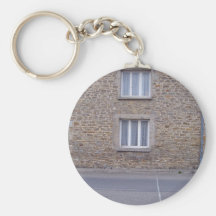 Windows im rauen Steinwand-Haus mit Spitze Curtai Schlüsselanhänger