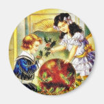 Zwei Kinder, welche die Kugel mit Weihnachtsgesche Kühlschrankmagnet