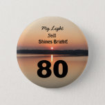 80th Birthday Sunset My Light Still Shines Bright Button<br><div class="desc">Give a happy 80th birthday button to express his "My Light Still Shines Bright" Gefühl. A bold design with a black and gold sunrise on peaceful lake sends a botschaft of förderung and love. An endearing gieß für an inspiring birthday celebration.</div>