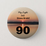 90th Birthday My light Still Shines Bright Button<br><div class="desc">Give a happy 90th birthday button to express his "My Light Still Shines Bright" Gefühl. A bold design with a black and gold sunrise on peaceful lake sends a botschaft of förderung and love. An endearing gieß for an inspiring ninetieth birthday celebration.</div>