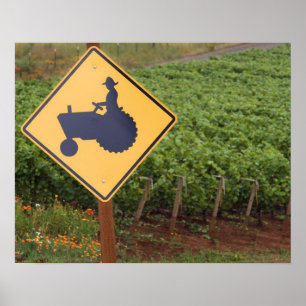 A yellow tractor crossing sign in the vineyard poster