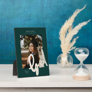 Abschlussankündigung mit goldenem Schriftzug und F Fotoplatte