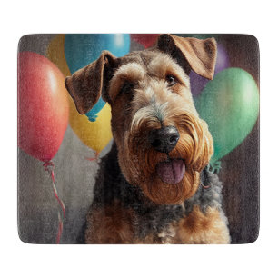 Airedale Hund mit Kuchen und Ballons Schneidebrett