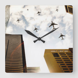 Airplanes flying over buildings quadratische wanduhr