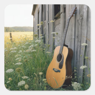 Akustische Gitarre an einer ländlichen Scheune leh Quadratischer Aufkleber
