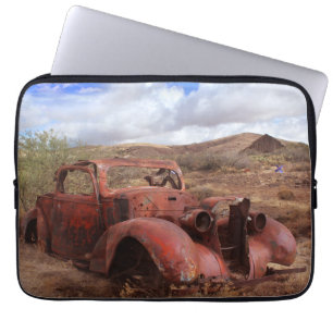 Altes Auto, das in der Wüsten-Landschaft verrostet Laptopschutzhülle
