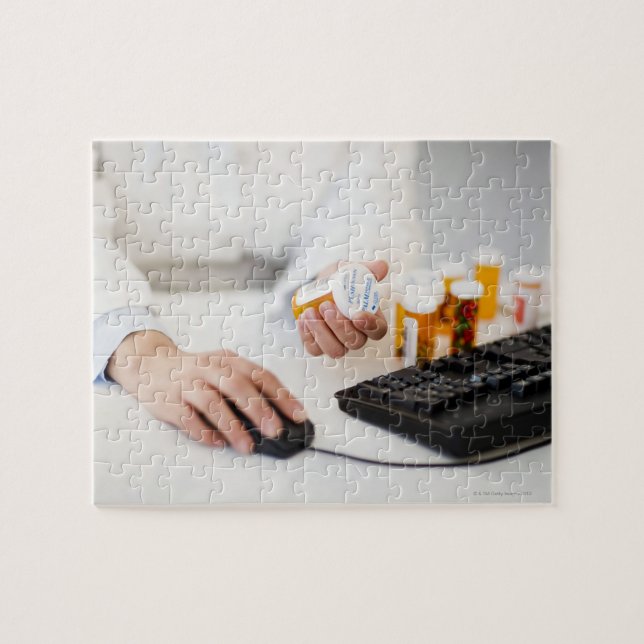 Apotheker mit Pillenflaschen am Computer Puzzle (Horizontal)