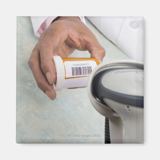 Apothekerin, die eine Flasche mit Barcode abtastet Magnet