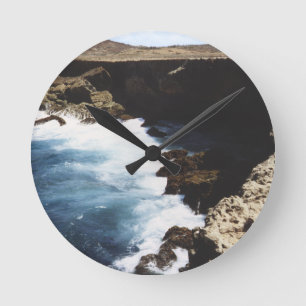 Aruba-Ozean, der auf den Felsen zusammenstößt Runde Wanduhr