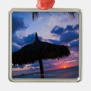 Aruba, Silhouette von palapa auf Strand an Ornament Aus Metall
