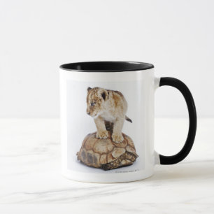 Babylöwe stehend auf Schildkröte, weißer Tasse