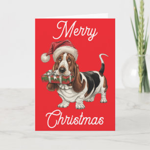 Basset Hound in Weihnachtsmannmütze im Mund Karte
