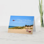 Beach Santa Greeting Card Feiertagskarte<br><div class="desc">Ein skurriler Weihnachtsgruß mit dem Weihnachtsmann und seinem Schlitten am Strand mit Skywriting-Flugzeug,  das eine frohe Weihnachtsbotschaft fliegt.</div>