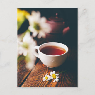 Becher mit schwarzem Tee und zwei Kamille-Blume Postkarte