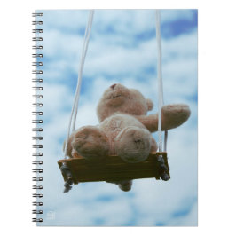 Beertje op schommel met bewolkte blauwe lucht. notizblock