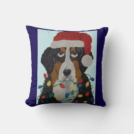 Berner Sennenhund in Weihnachtslichtern verheddert Kissen