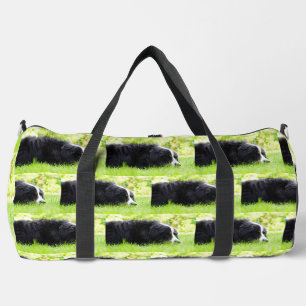 Berner Sennenhund liegt im Gras Duffle Bag