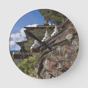 Bhutanesisch schreibt auf Felsen und nepalesisch c Runde Wanduhr