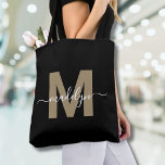 Black Gold Trendy Modern Script Name Monogram<br><div class="desc">Personalisierte elegante Black Gold Trendy Moderne Skriptname Monogram Tote Bag. Mit dieser schicken Tasche können Sie dem Alltag eine Touch Glamour und Eleganz verleihen. Diese Tasche mit einem eleganten Goldvorschuss (Achtung: das Gold ist flach, ohne Schimmer oder Folie) auf einem knackigen schwarzen Hintergrund zentriert und mit einem sauberen, modernen Design...</div>
