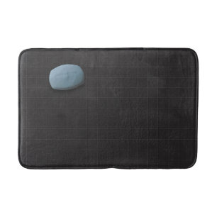 Blaue Seife auf schwarzem Tile Badematte