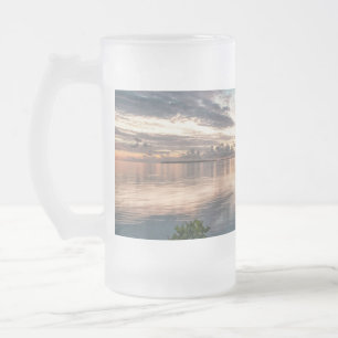 blauer Himmel mit roten und dunklen Wolken, die au Mattglas Bierglas