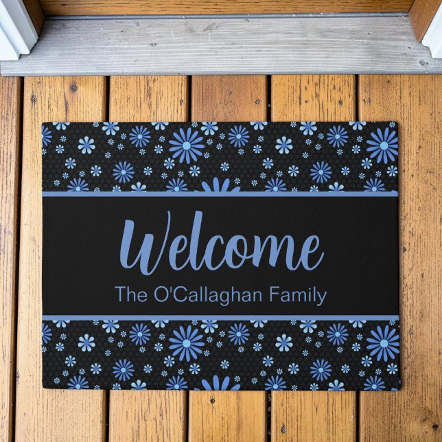 Blauer und schwarzer Blume Power Retro Fußmatte (A blue retro daisy pattern in a moody, modern aesthetic on a custom welcome mat, placed on a deck.)
