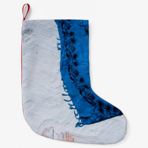 Blauer und schwarzer Blumenschal auf weißem Sand Kleiner Weihnachtsstrumpf