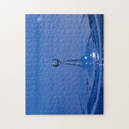 Blauer Wassertropfen in Bewegung auf einem Puzzle