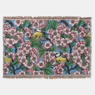 Blauzungenvögel im blühenden Kirschbaum auf blau Decke