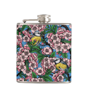 Blauzungenvögel im blühenden Kirschbaum auf blau Flachmann