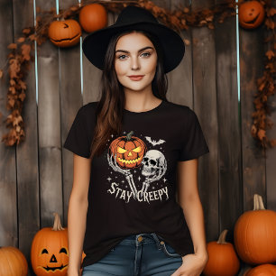 Bleibende gruselige Skeletthände halten Kürbis und T-Shirt