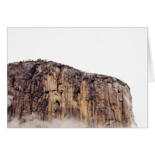 Bloße Klippe, die über Wolken steigt