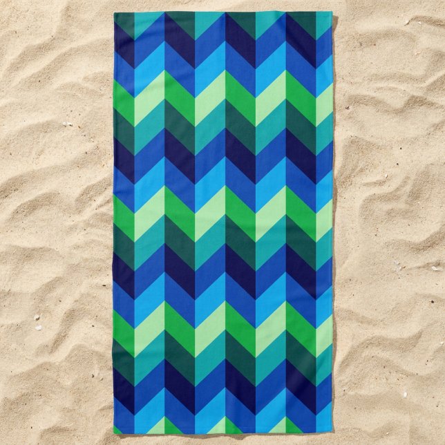 Blue Green Ombre Chevrons Beach Handtuch (Blue Green Ombre Chevrons Beach Towel lying in the sand.)