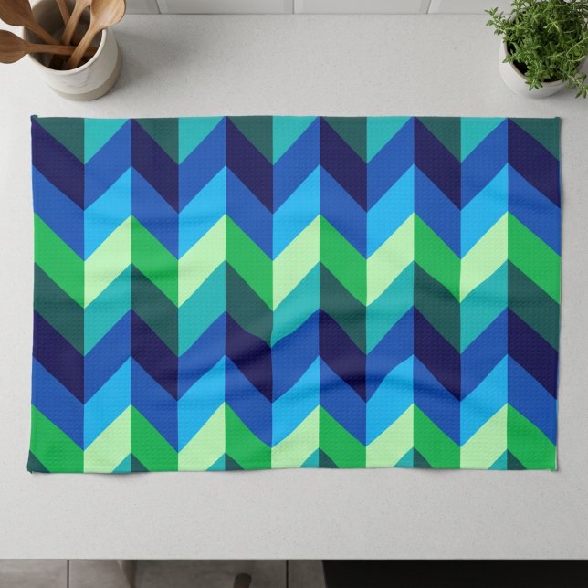 Blue Green Ombre Chevrons Küche Handtuch (Blue Green Ombre Chevrons Kitchen Towel lying on a counter top in a modern style kitchen.)