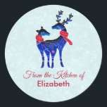 Blue Nordic Christmas Reindeer Pair Kitchen Runder Aufkleber<br><div class="desc">Ein Weihnachtsaufkleber. Ein Weihnachtsgrüßen und der Text: Aus der Küche von. Personalisieren Sie mit Ihrem Namen. Mit einem hellgrün-weiß schneebedeckten Hintergrund. Illustriert mit einem blauen skandinavischen Hirsch mit roten Schals. Mit dekorativen Markierungen auf ihren Körpern.</div>