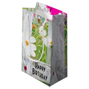 Blume des Geburtstagskosmos im Zaun Kleine Geschenktüte
