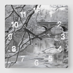 Bogen-Brücke über gefrorenem Fluss im Winter Quadratische Wanduhr