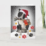 Border Collie Geschenk von Santa Cards Feiertagskarte<br><div class="desc">Border Collie mit Weihnachtsmannmütze,  während sie große Knochen aus Santa vor dem Hintergrund des schneebedeckten Himmels auf einer freundlichen Weihnachtskarte von Friskybizpet Designs tragen.</div>