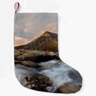BRAUNER BERG IN DER NÄHE EINES GEWÄSSERS UNTER BED KLEINER WEIHNACHTSSTRUMPF