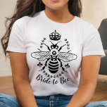 Braut zu Bee Honeybee Crown Wedding | PERSONALISIE T-Shirt<br><div class="desc">Dieser wunderschöne, schlicht elegante T - Shirt sagt "Bride to Bee" und zeigt eine Honigbienen-Silhouette, umgeben von einer Krone, Lilie und einem Lorbeerkranz. Sie können auch den Text "Bride to Bee" für einen anderen Anlass ändern oder weiter anpassen, um mehr Text hinzuzufügen. Dieses Design für dunkelfarbene T - Shirt in...</div>