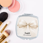 Bridesmaid Bugbeige elegant Taschenspiegel<br><div class="desc">Beige,  cremefarbene Unterlage. Mit einem großen Bogen dekoriert. Personalisieren Sie den Namen Ihrer Brautjungfrau und fügen Sie ihn hinzu. Schwarzes handgeschriebenes Stilskript.</div>