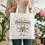 Bridesmaid Club Coquette Floral Bow Wedding Party Tragetasche<br><div class="desc">Gift your bridal party something truly special with this Bridesmaid Club tote bag! Featuring a romantic coquette-style cream bow, delicate pink flowers, and elegant gold rings, this bag is a must-have for any modern wedding. Use it as a wedding welcome bag, a bridesmaid proposal gift, or for carrying essentials on...</div>