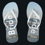 Bridge Ocean Waves Beach Sand Flip Flops<br><div class="desc">Hübscher blauer Himmel mit leicht flauschigen weißen Wolken, blaues Meer, abstürzenden Ozeanwellen und Strand Sand. Unisex Flip Flops mit Bride und Datum der Ehe geschrieben in einem weißen Text. PERSONALISIEREN Sie mit Ihrem Hochzeitstag (oder löschen Sie Text). Der Hochzeitstag ist im Sand geschrieben. Wählen Sie breite oder schlanke Gurte und...</div>