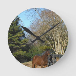 Brown-Pferd gegen einen Zaun Runde Wanduhr
