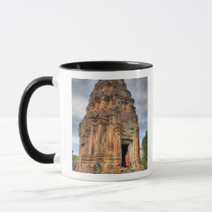Buddhistischer Mönch steht im Eingangsbereich eine Tasse