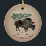 Buffalo Bison Santa Arrow Schnee Weihnachtsbaum Keramik Ornament<br><div class="desc">Illustration eines Büffels mit einer Weihnachtsmannmütze mit einem schneebedeckten Weihnachtsbaum,  der an den Rücken gebunden ist. Schneeflecken und Karton inspiriert Hintergrund mit Pfeildesign.</div>