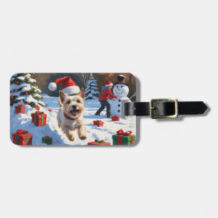 Cairn Terrier läuft im Schnee mit Weihnachtsmütze Gepäckanhänger