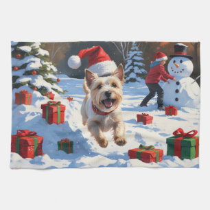 Cairn Terrier läuft im Schnee mit Weihnachtsmütze Geschirrtuch